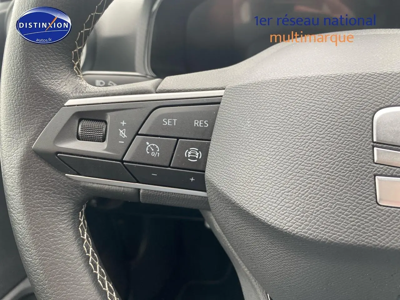 Gros plan sur le volant cuir noir de la SEAT Ibiza 2025 avec commandes multifonctions côté gauche.