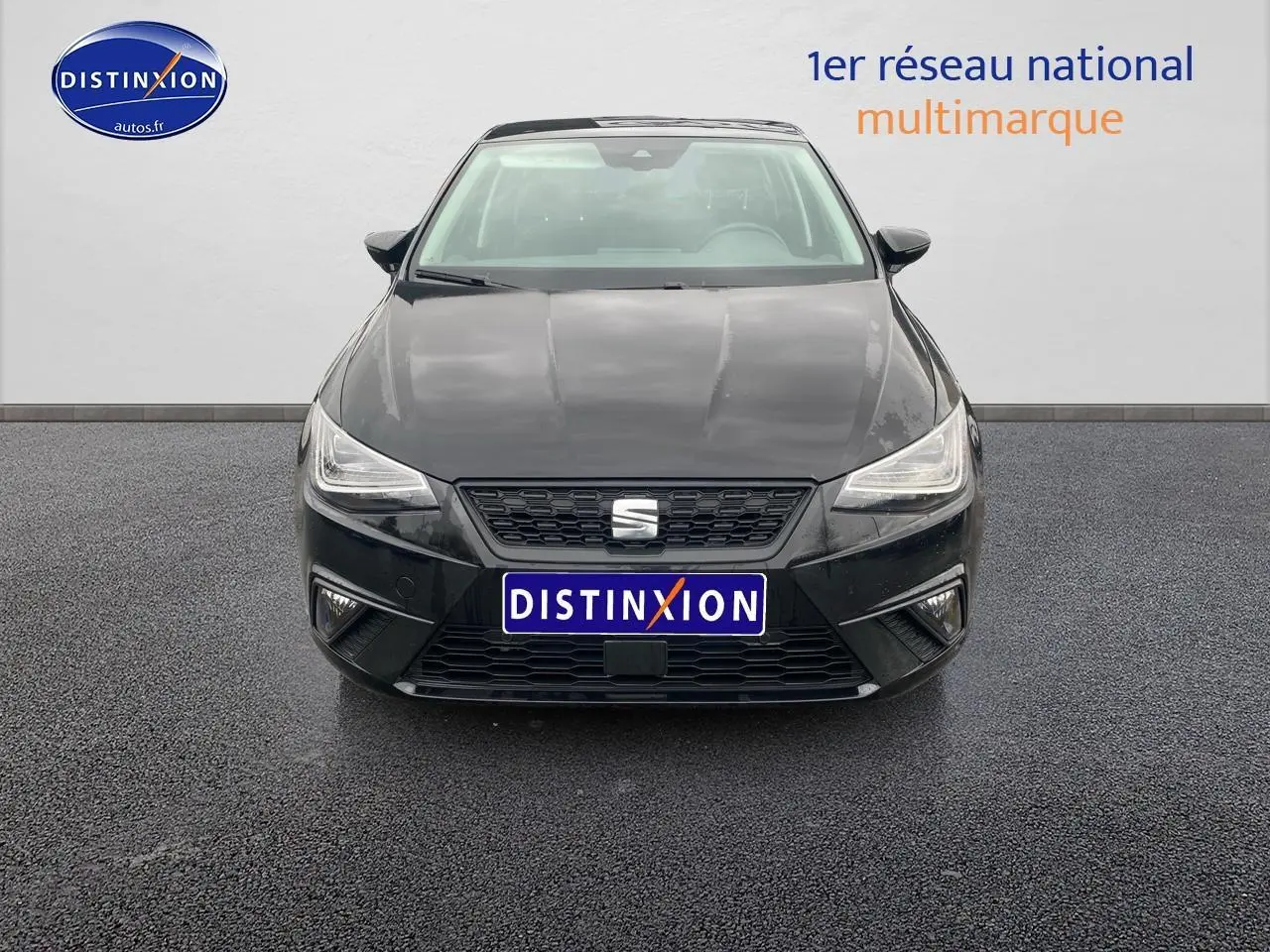 Vue frontale d'une SEAT Ibiza noir minuit avec calandre noire et phares LED triangulaires allumés.
