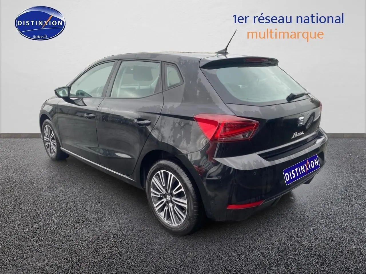 Vue 3/4 arrière droite d'une SEAT Ibiza noir minuit avec jantes alliage et signature Ibiza manuscrite sur le hayon.