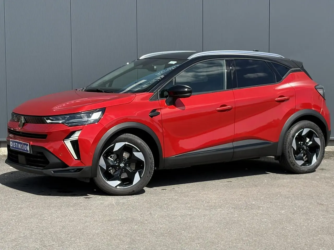 Vue de profil droit du Renault Captur E-Tech Full Hybrid 145 Techno rouge Désir avec toit noir étoilé et jantes aluminium 18 pouces.