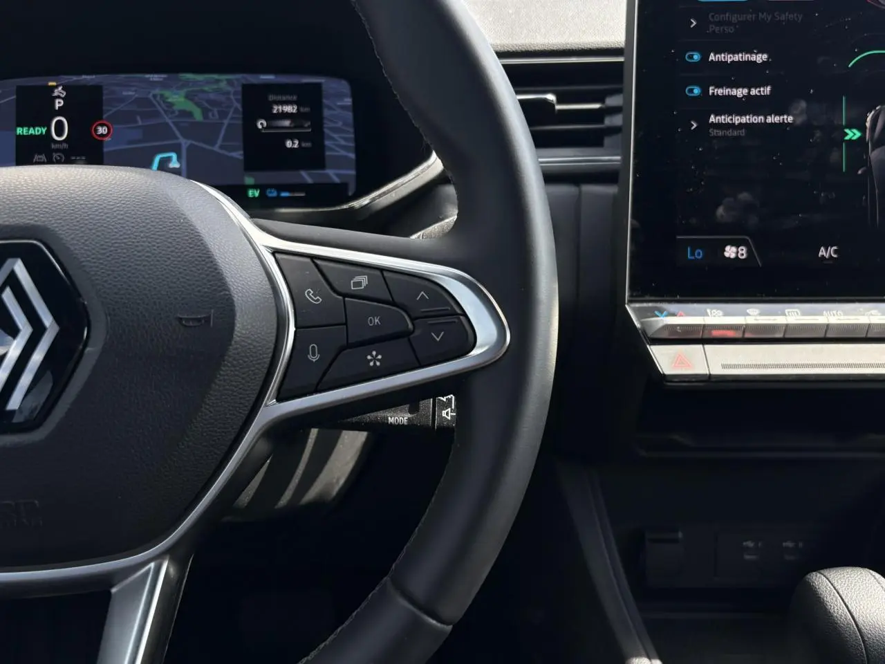 Vue rapprochée du volant cuir multifonctions et tableau de bord numérique du Renault Captur E-Tech 2025, intérieur noir.