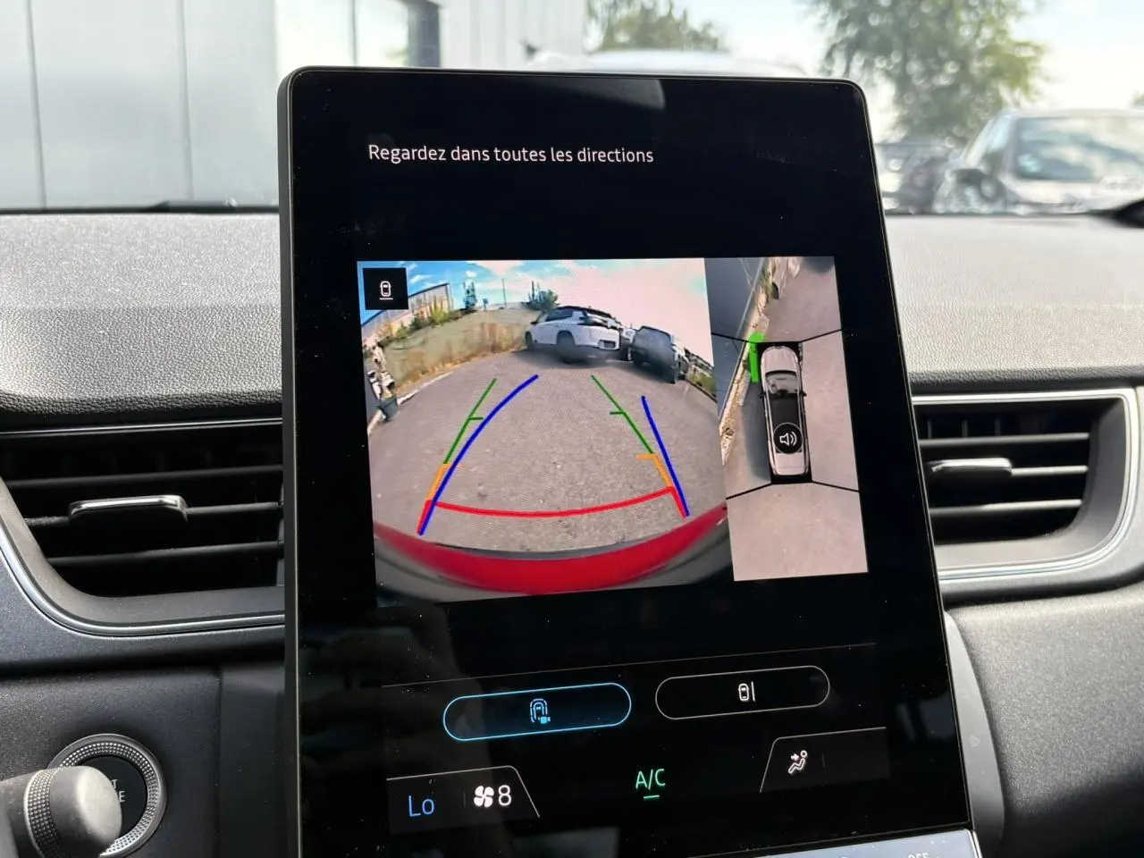 Écran central montrant la caméra 360° du Renault Captur E-Tech rouge, vue arrière avec guidage de recul.