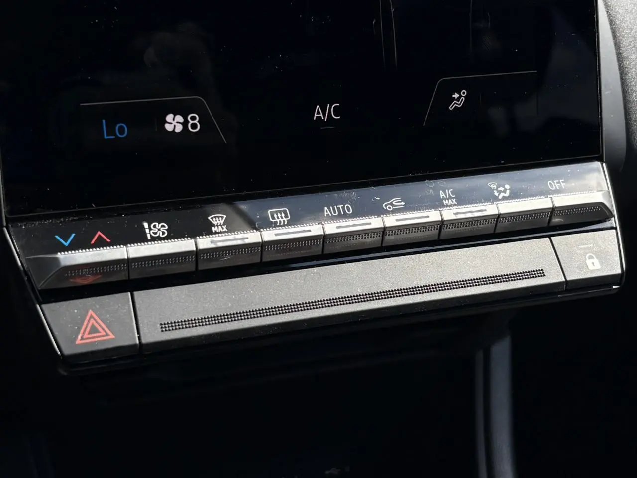 Vue rapprochée des commandes de climatisation et sécurité du tableau de bord du Renault Captur E-Tech Full Hybrid 2025.