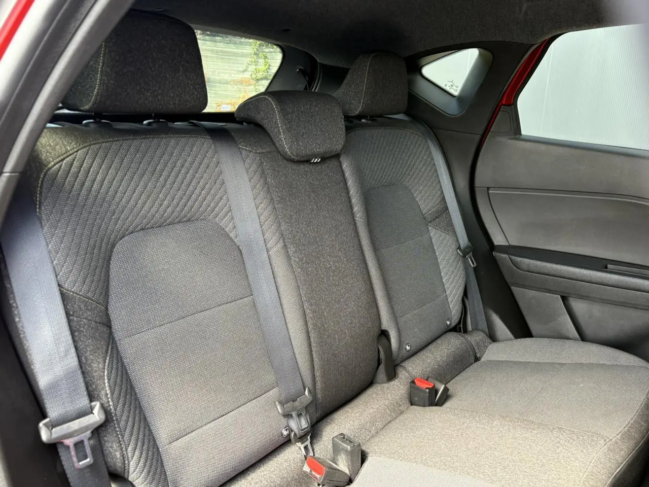 Vue intérieure côté droit sur la banquette arrière grise du Renault Captur E-Tech Full Hybrid 2025, avec ceinture de sécurité visible.