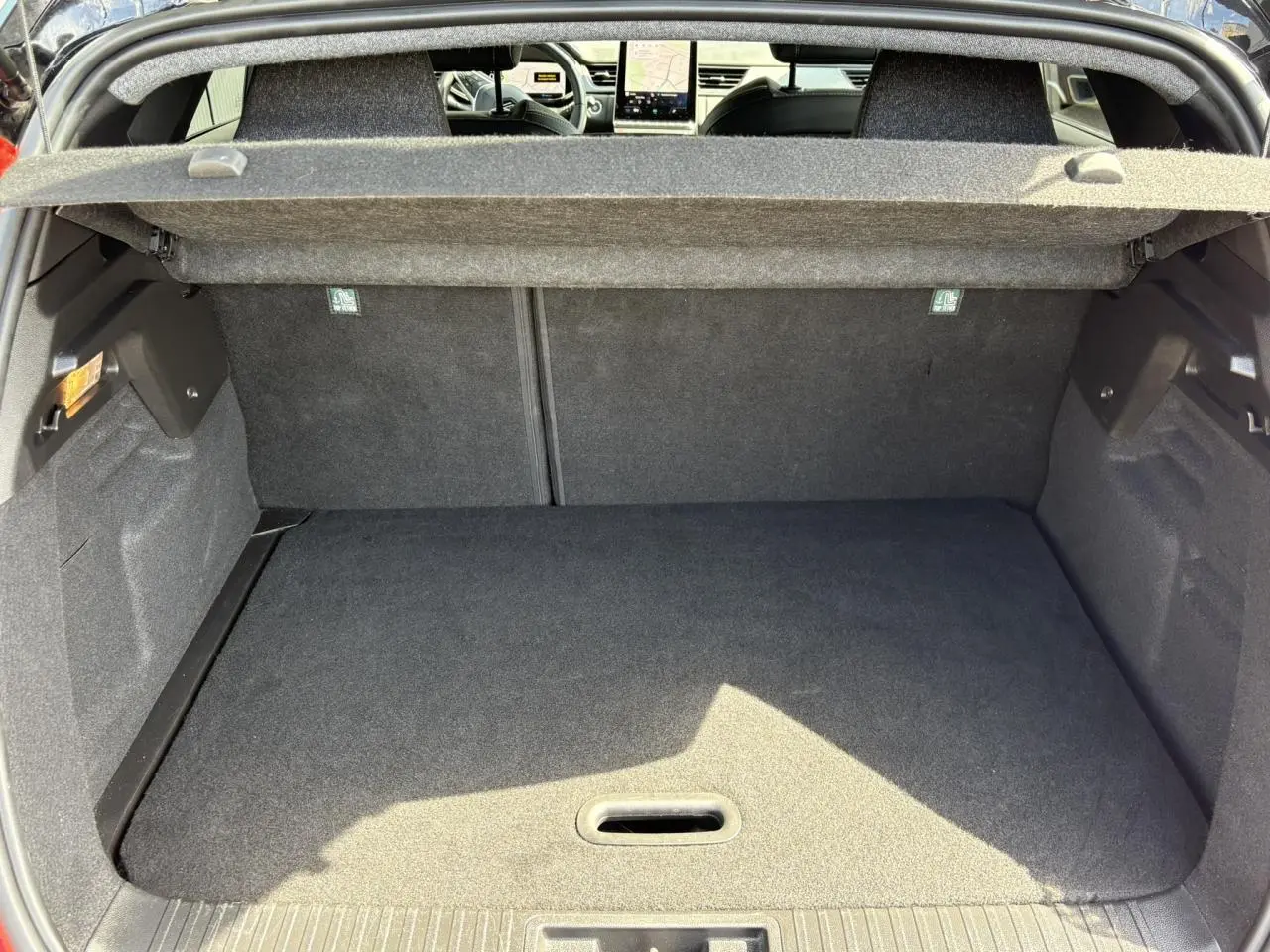 Vue du coffre ouvert d'un Renault Captur E-Tech rouge, montrant l'espace de chargement et l'intérieur arrière noir.