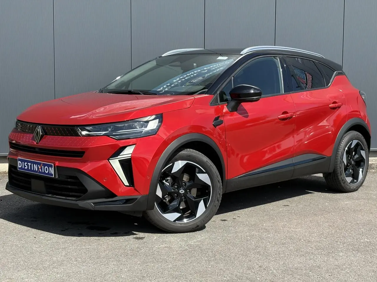 Renault Captur E-Tech Full Hybrid 145 Techno rouge Désir, vue 3/4 avant avec jantes noires et toit noir étoilé.