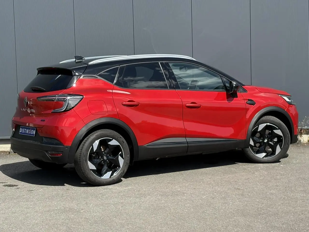 Vue latérale droite du Renault Captur E-Tech Full Hybrid 145 Techno rouge Désir avec toit noir étoilé et jantes 18 pouces.