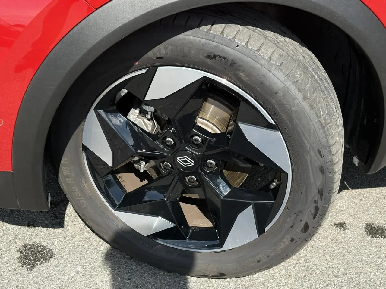 Gros plan sur la roue avant droite du Renault Captur Rouge Désir, jante aluminium noire et argentée 18 pouces.