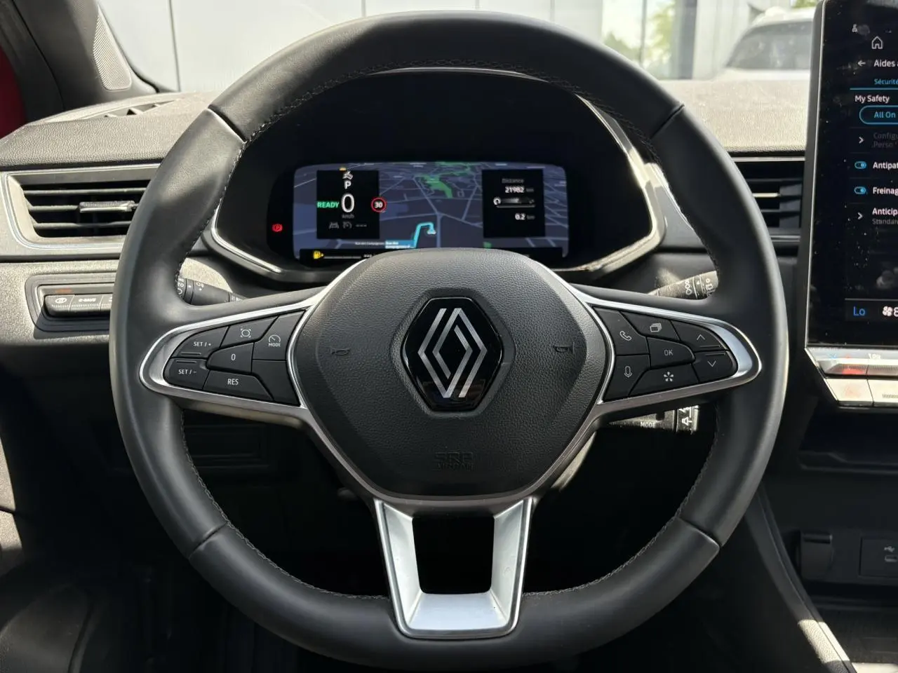 Vue centrée sur le volant cuir multifonctions Renault Captur E-Tech 2025 avec tableau de bord numérique et écran tactile.