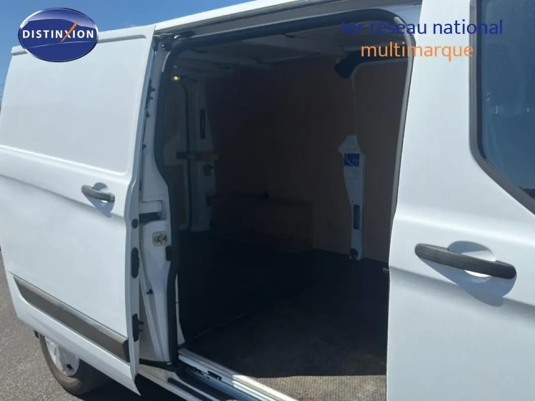 Vue latérale gauche d’un Ford Transit Custom blanc avec porte latérale coulissante ouverte montrant l’espace de chargement vide.
