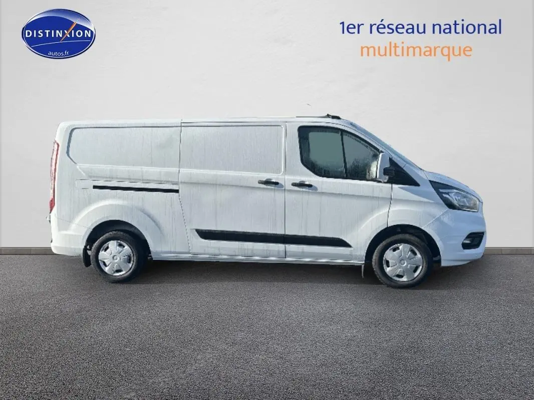 Vue de profil côté gauche du fourgon blanc Ford Transit Custom 2021 avec porte latérale et vitres surteintées.