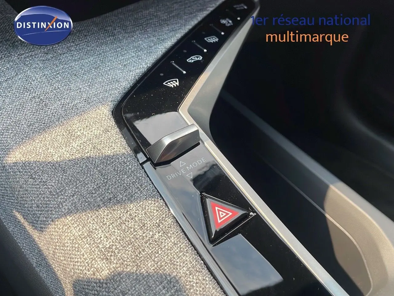 Gros plan sur la console centrale du Peugeot 3008 Hybrid gris, mettant en valeur le bouton de mode de conduite et le triangle de détresse.