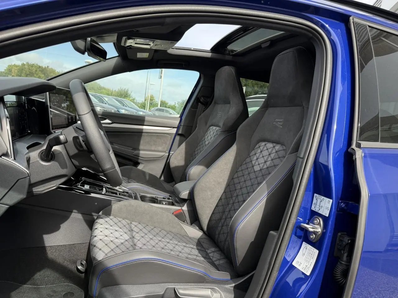 Vue intérieure côté gauche de la Volkswagen Golf 1.5 eTSI 2025 Bleu Lapiz, sièges sport R-Line en tissu et ArtVelours.