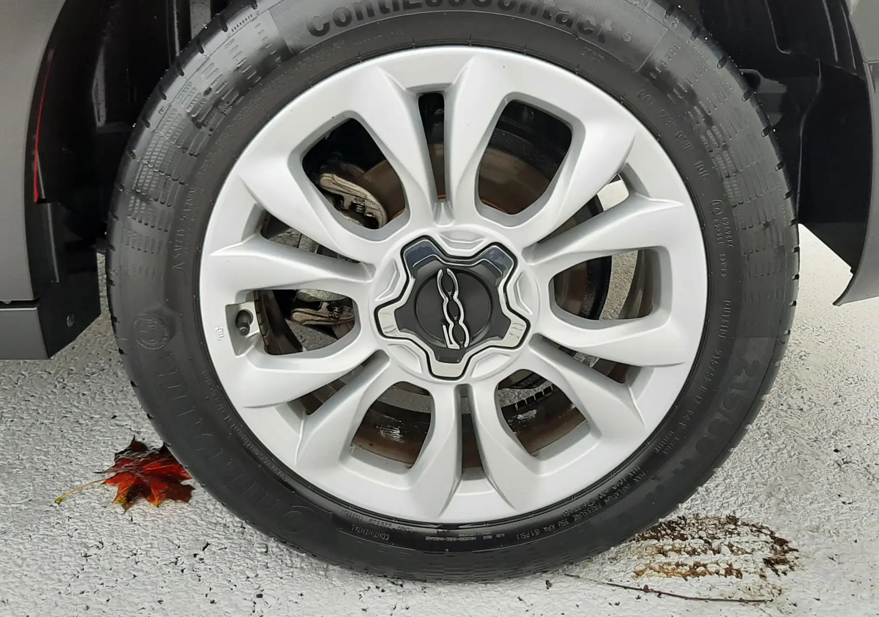 Intérieur de la Fiat 500X rouge vue côté conducteur, tableau de bord brillant rouge et volant multifonction noir.