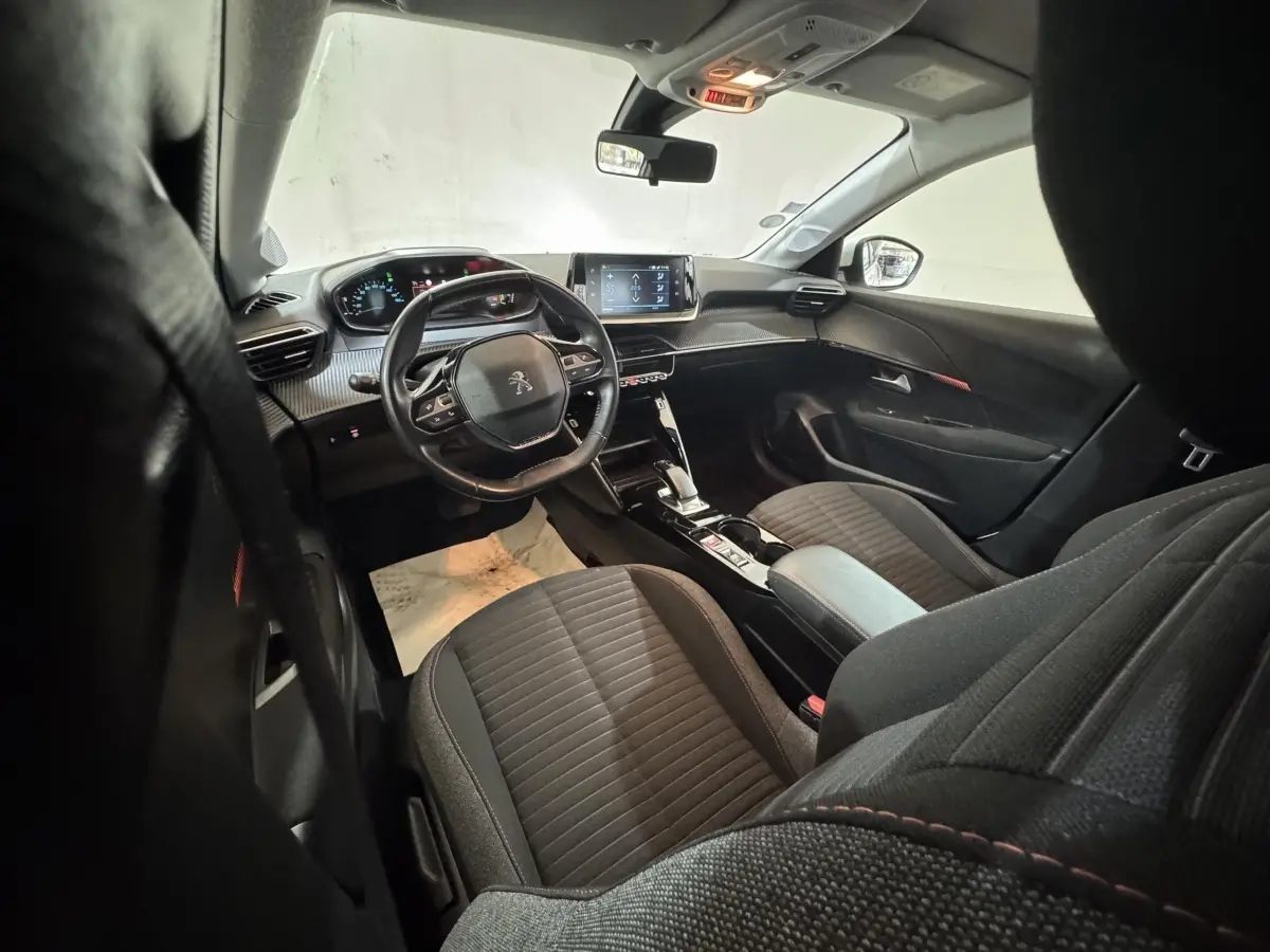 Vue intérieure avant droite de la Peugeot 208 Electrique Active Business 2020, sièges noirs et tableau de bord numérique.