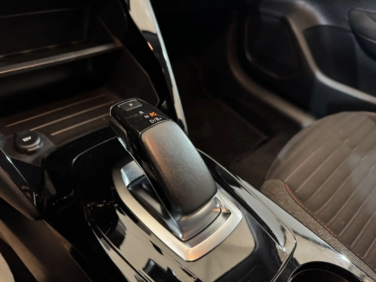 Le levier de vitesses automatique noir de la Peugeot 208 Electrique Active Business vu en gros plan côté console centrale.