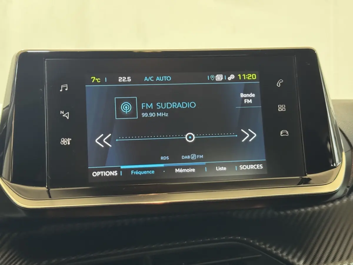 Écran tactile central 7 pouces de la Peugeot 208 électrique Active Business, affichant la radio FM sur fond noir.