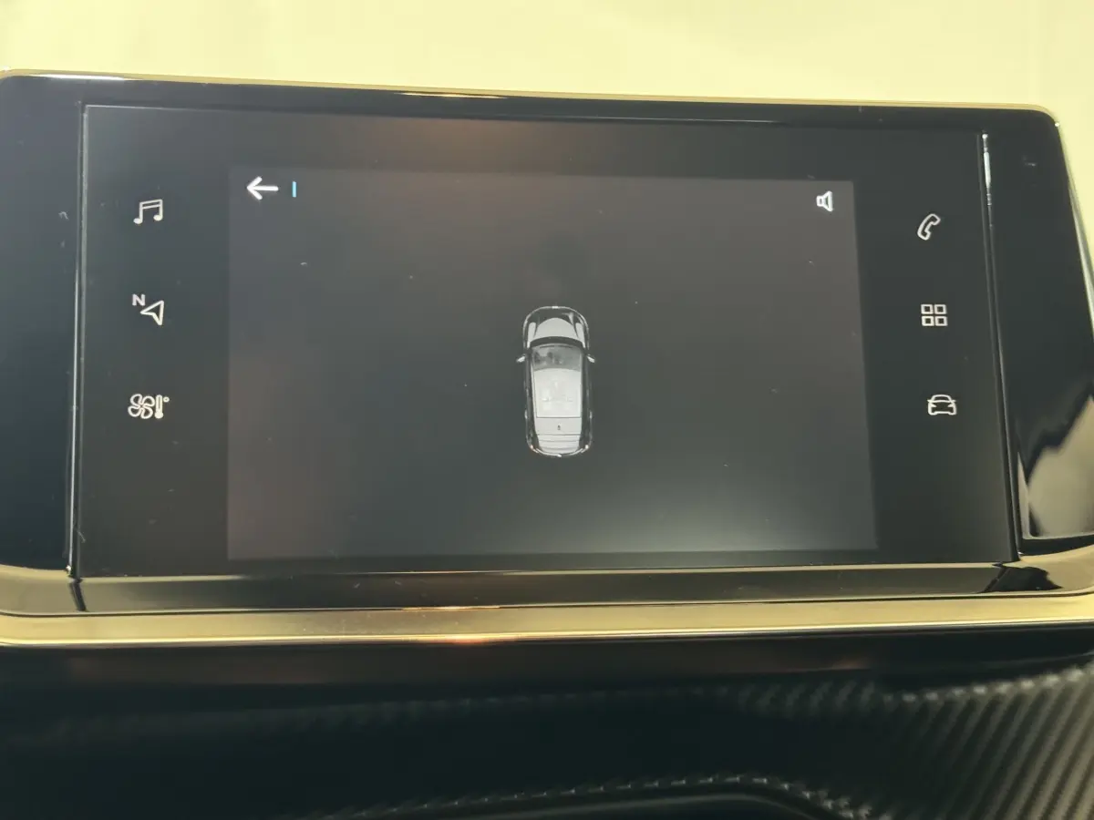 Écran tactile central de la Peugeot 208 électrique montrant la vue aérienne du véhicule en noir.