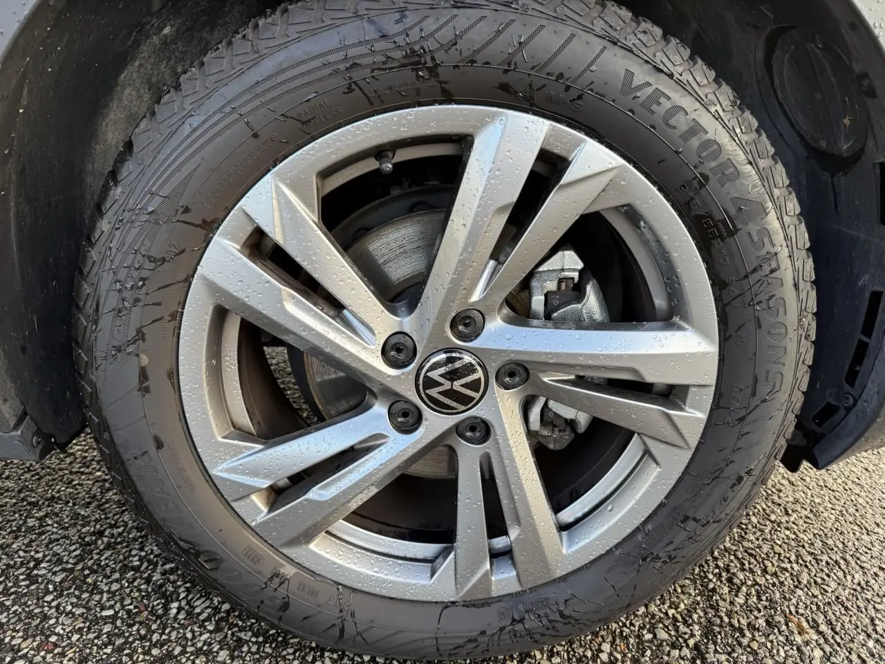 Gros plan sur la jante en alliage léger gris galvanisé 17 pouces avec logo Volkswagen au centre, roue mouillée.