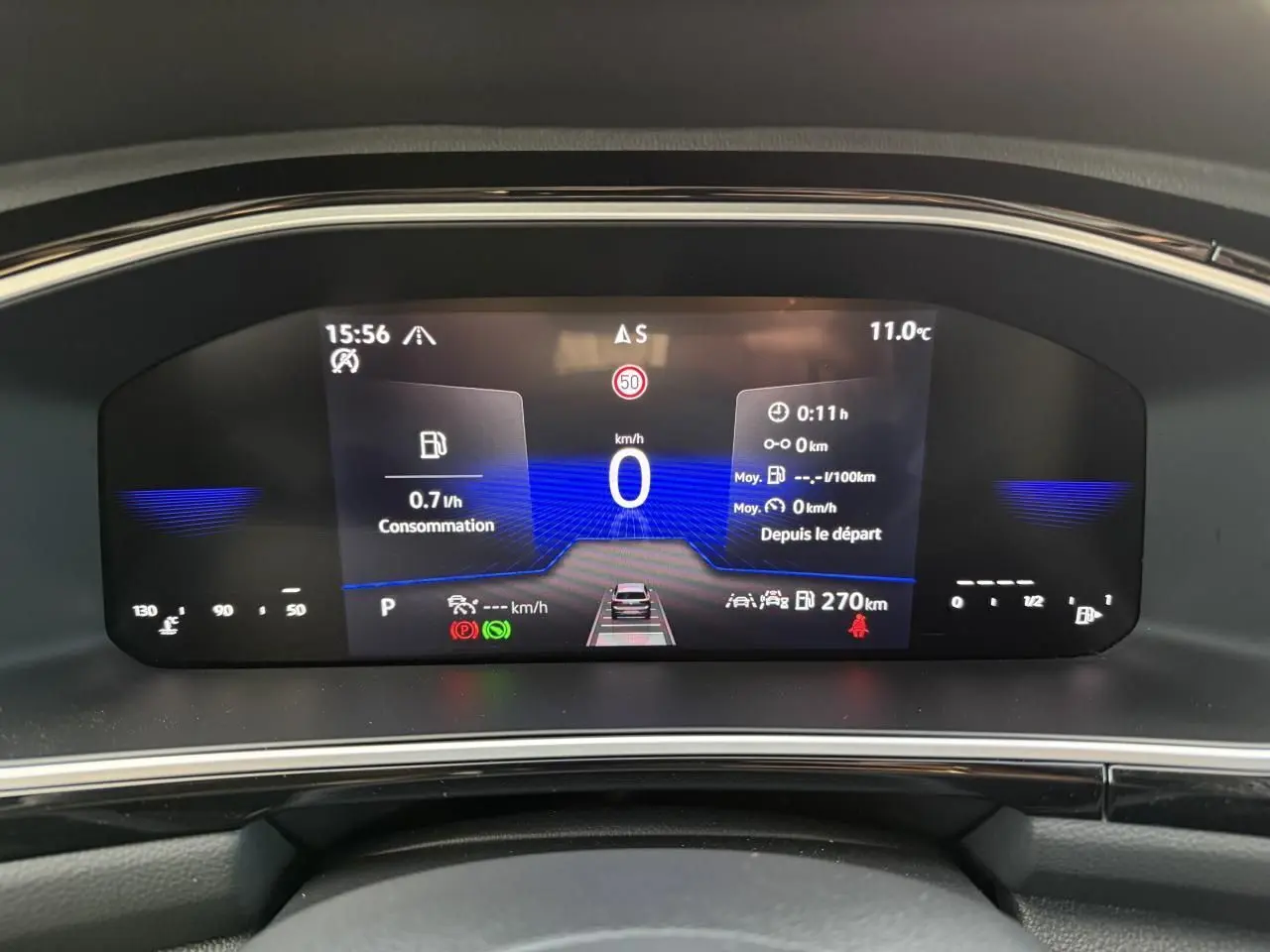 Vue rapprochée du tableau de bord digital du Volkswagen T-Roc 2025 affichant la consommation et la vitesse à 0 km/h.