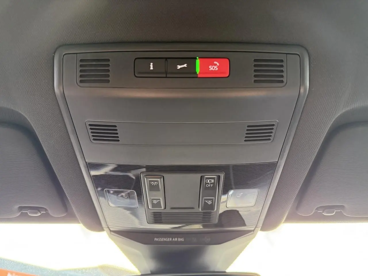 Vue intérieure du plafonnier noir du Volkswagen T-Roc 2025 avec boutons SOS et éclairage intégré.