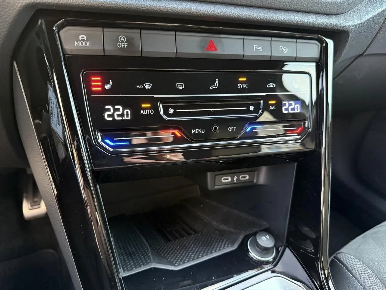 Détail de la console centrale noire du Volkswagen T-Roc 2025 montrant la climatisation automatique tactile et les ports USB.