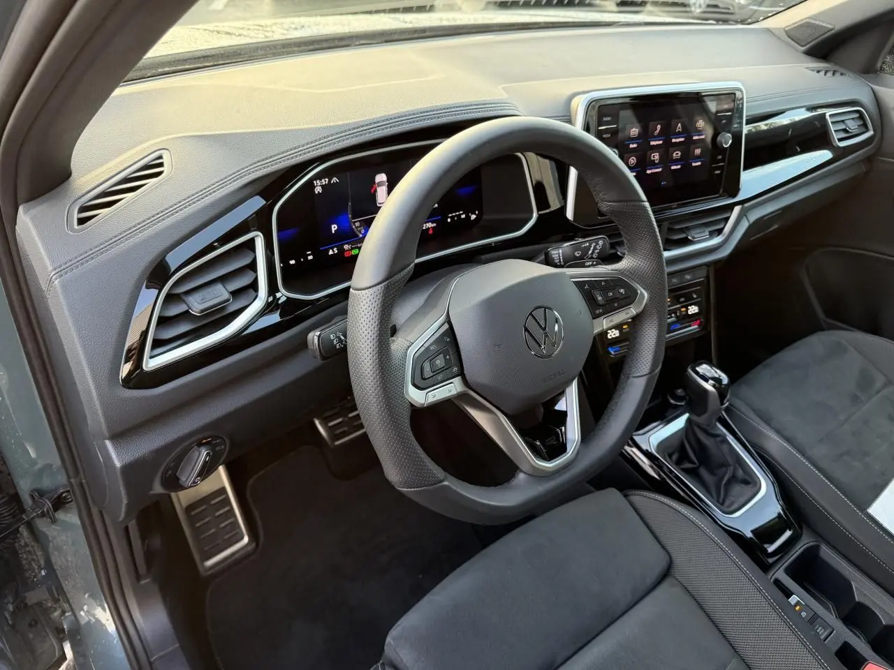 Vue intérieure côté conducteur du Volkswagen T-Roc 2025, volant cuir multifonction et tableau de bord digital.