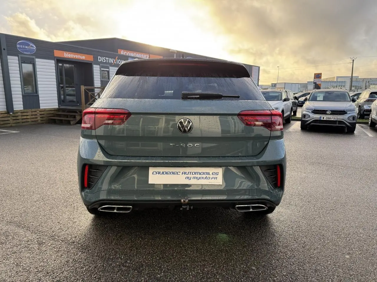 Vue arrière du Volkswagen T-Roc bleu avec double sortie d’échappement et attelage amovible visible.