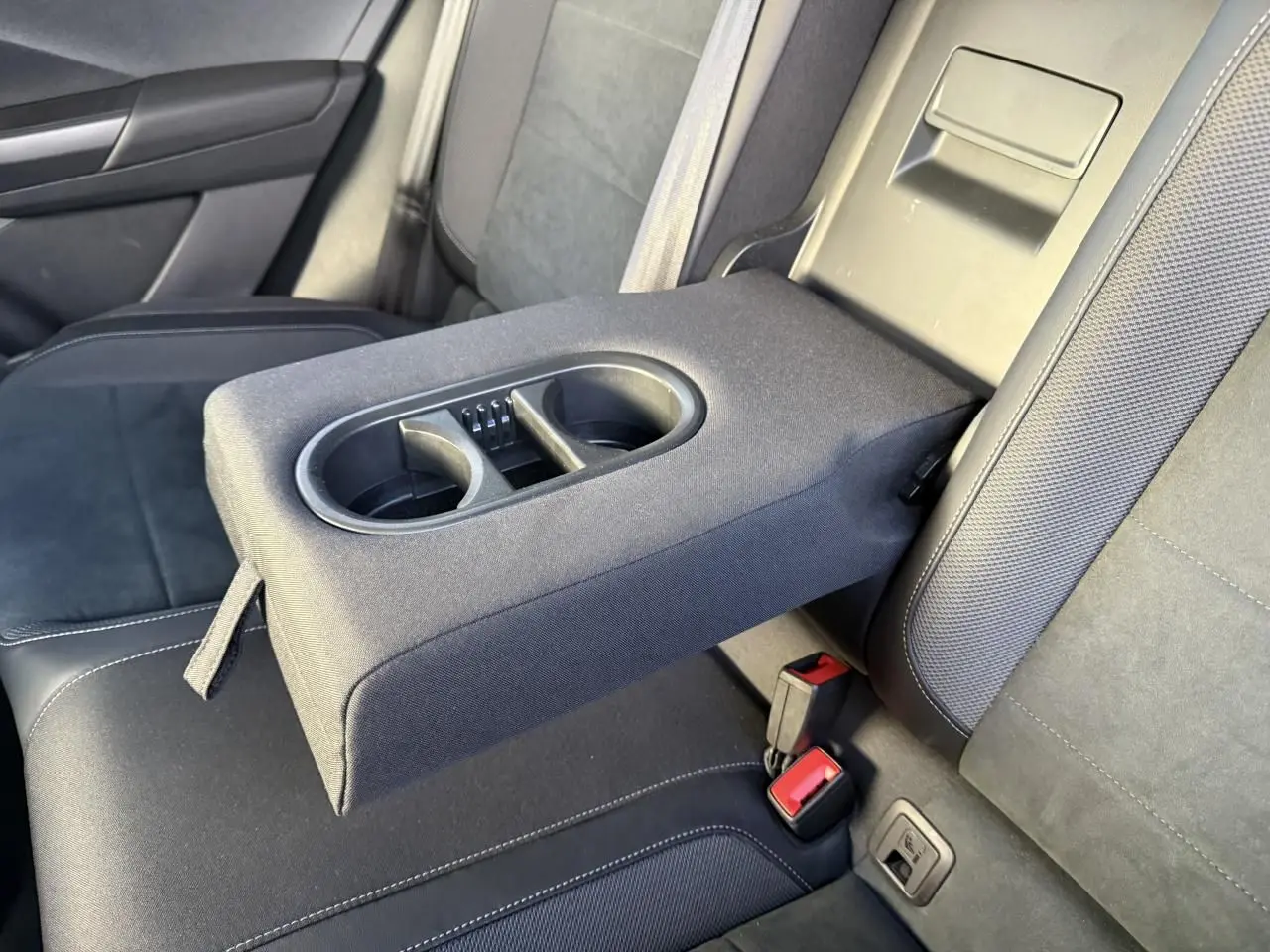 Accoudoir central arrière déployé avec porte-gobelets dans l’habitacle noir du Volkswagen T-Roc 2025.