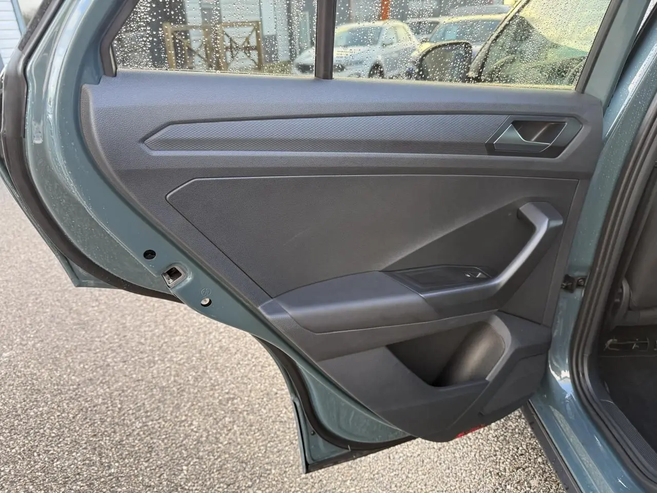 Vue rapprochée de la porte arrière gauche bleu du Volkswagen T-Roc 2025, montrant la garniture intérieure noire.