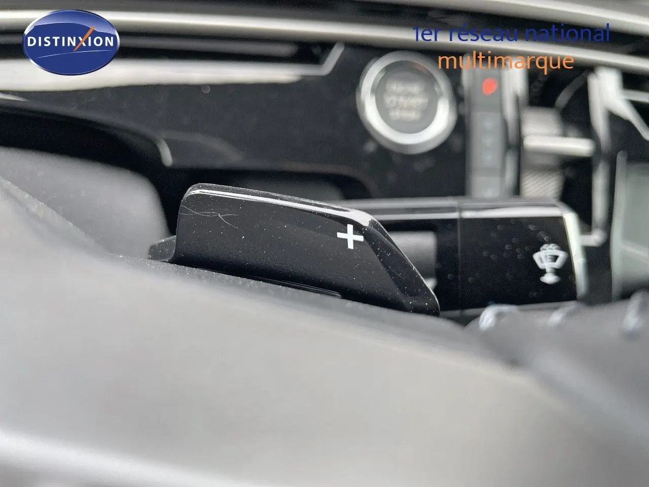 Gros plan sur la palette de changement de vitesse "+" du Peugeot 3008 noir perle hybride, intérieur moderne et épuré.
