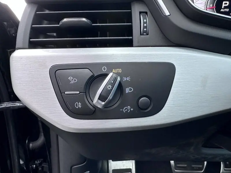 Gros plan sur le panneau de commandes des phares et éclairage intérieur de l'Audi A5 Cabriolet noir brillant, finition Avus 2023.