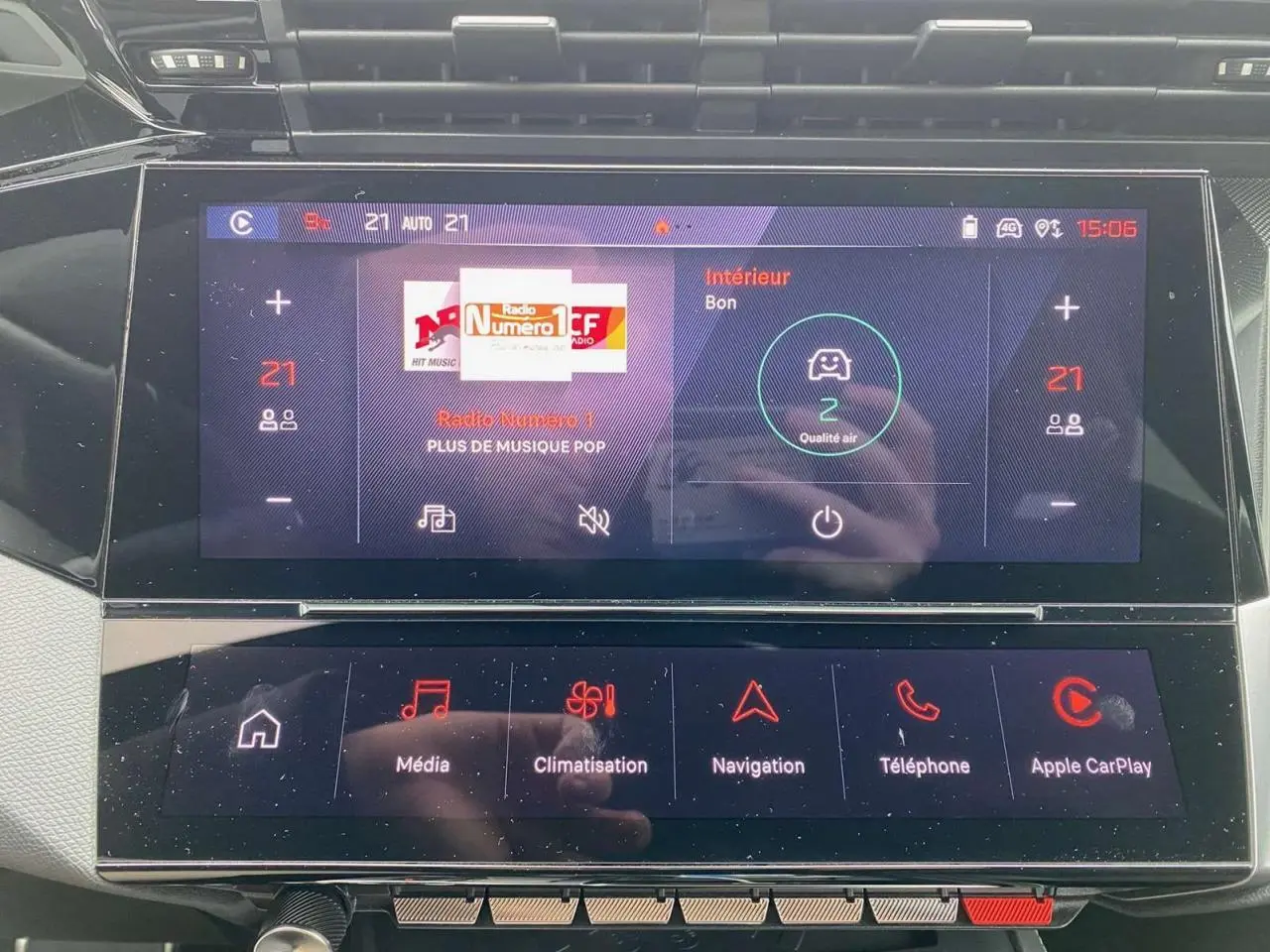 Écran tactile central de la Peugeot 308 GT 2022 affichant la climatisation et la radio, intérieur moderne et épuré.