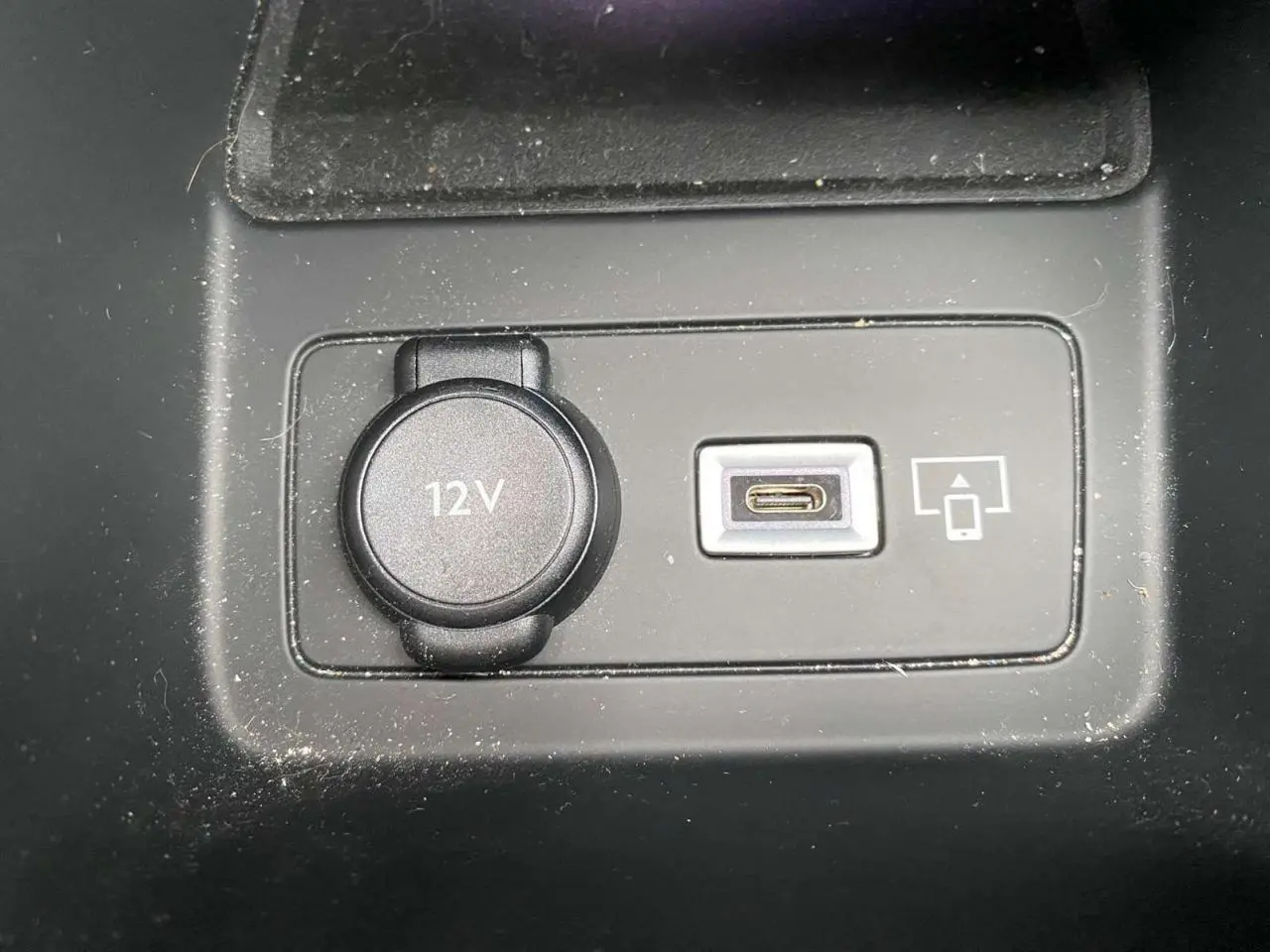 Prise 12V et port USB-C pour smartphone dans l'habitacle de la Peugeot 308 GT rouge Elixir, vue rapprochée du tableau central.