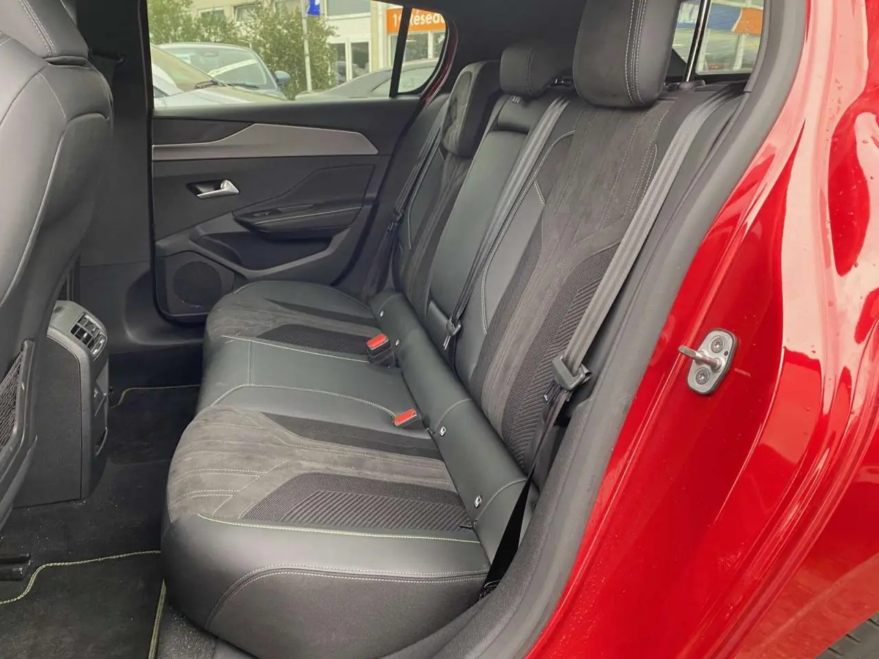 Vue intérieure côté droit sur la banquette arrière en cuir et alcantara de la Peugeot 308 rouge Elixir 2022.