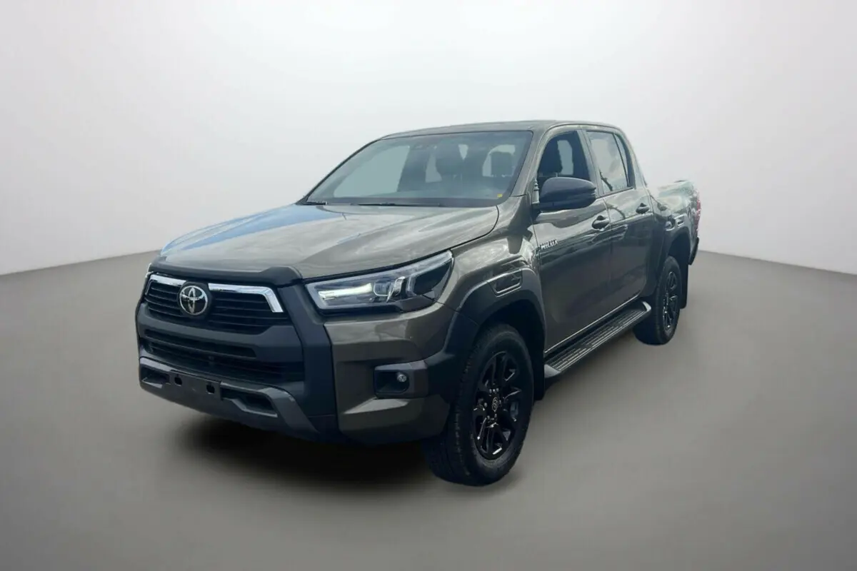 Toyota Hilux 2025 bronze impérial en 3/4 avant droit, avec calandre noire et jantes alliage noires distinctives.