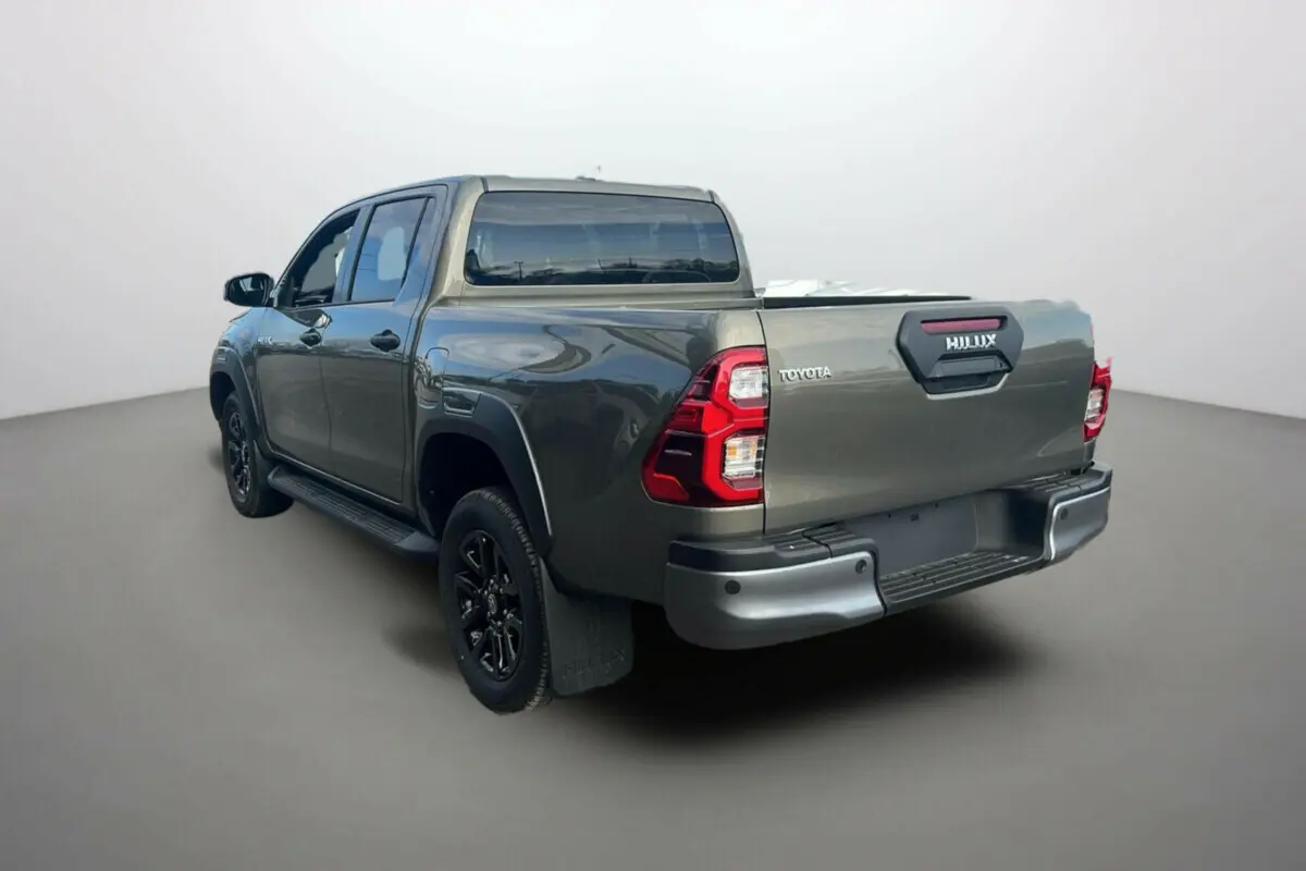 Toyota Hilux 4x4 2025 bronze impérial, vue 3/4 arrière droit mettant en valeur la benne et les feux arrière rouges.