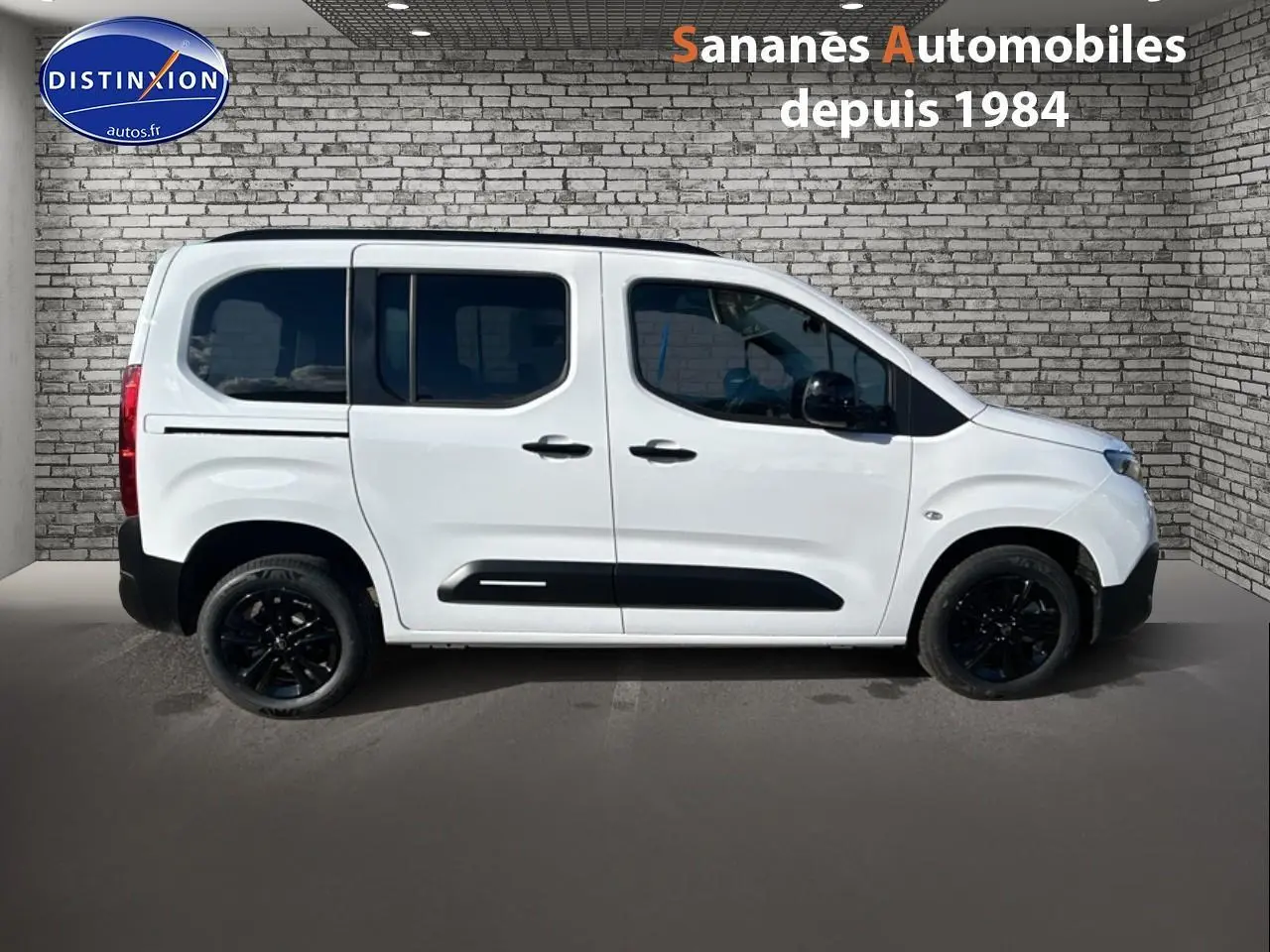 Vue de profil côté gauche d'un Citroën Berlingo blanc avec jantes noires et vitres arrière surteintées.