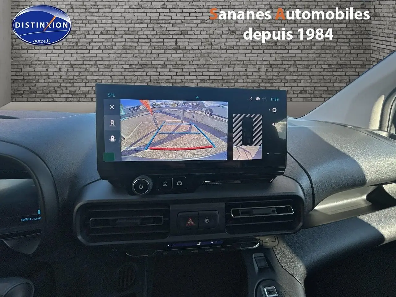 Vue rapprochée de l’écran central du tableau de bord du Citroën Berlingo blanc, affichant la caméra de recul.