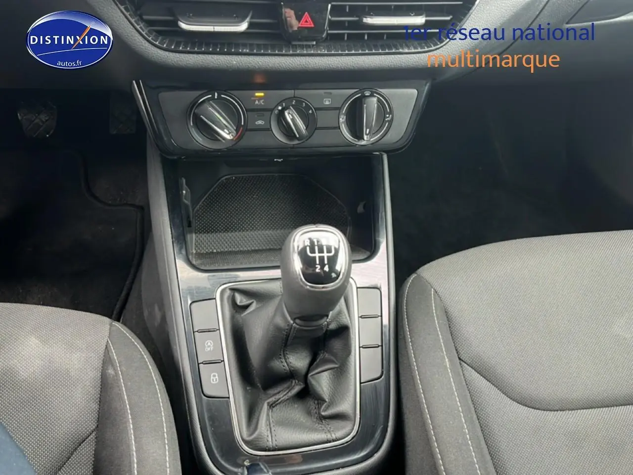 Vue rapprochée du levier de vitesses manuel noir et console centrale de la Skoda Fabia blanche, avec sièges gris visibles.