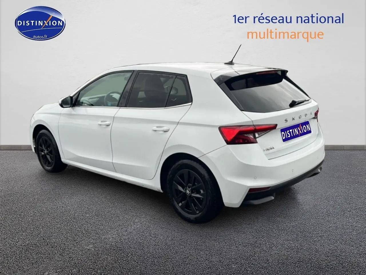 Vue 3/4 arrière droite d'une Skoda Fabia blanche 2025 avec jantes noires et vitres arrière teintées.