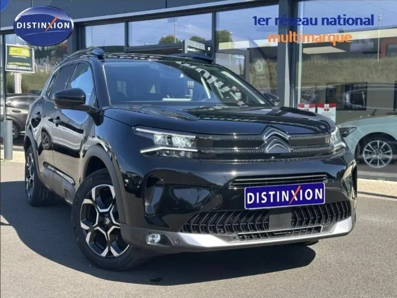Vue 3/4 avant d'un Citroën C5 Aircross 2025 noir Perla Nera avec calandre distinctive et jantes alliage bicolores.