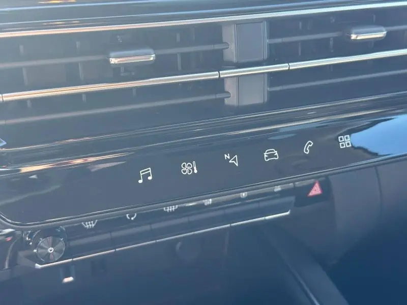 Détail du tableau de bord noir brillant du Citroën C5 Aircross 2025 avec commandes tactiles et aérateurs horizontaux.