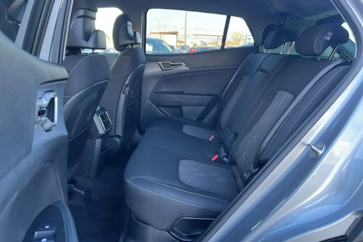 Vue intérieure arrière côté droit du Kia Sportage gris perle 2026, montrant la banquette tissu et les appuie-têtes.