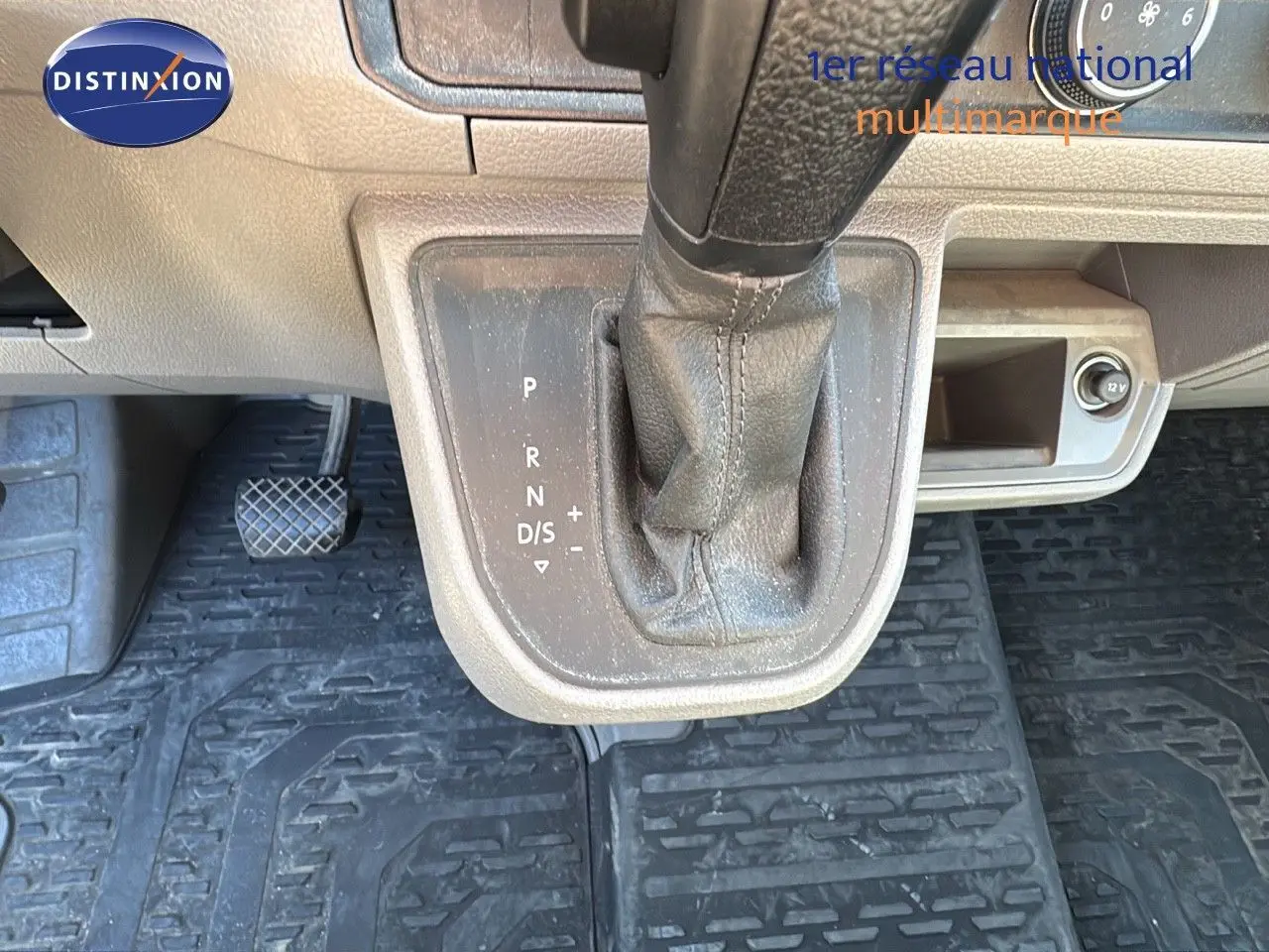 Le levier de vitesse automatique noir du Volkswagen Crafter 35 L3H3 2.0 TDI, vu de dessus avec pédales et prise 12V.