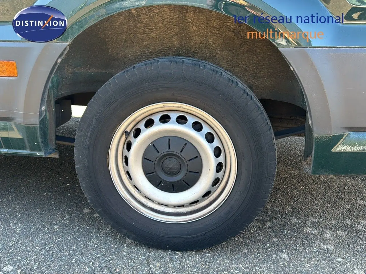 Gros plan sur la roue avant gauche du Volkswagen Crafter vert Ontario, soulignant la jante acier d'origine.