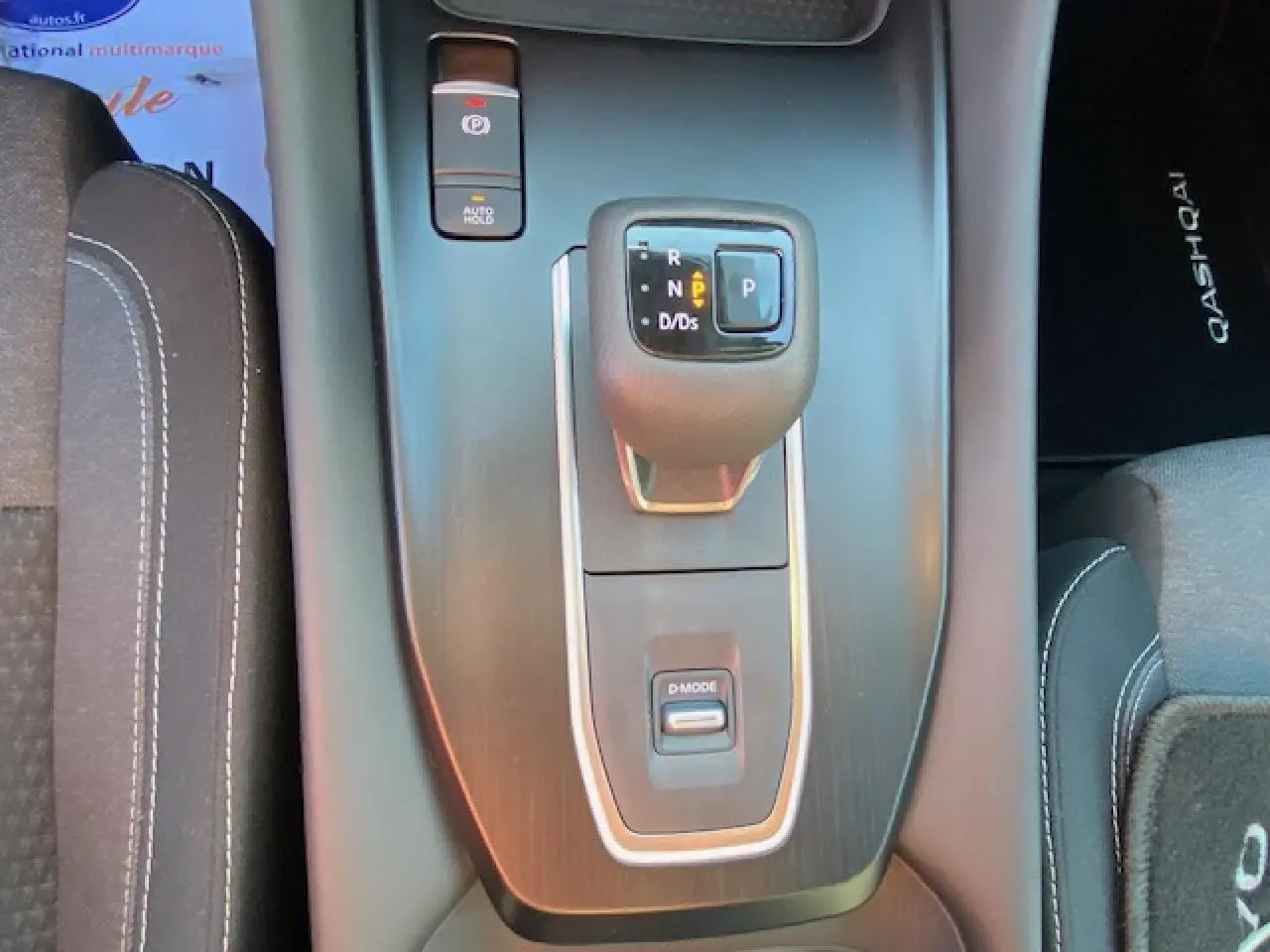 Vue rapprochée de la console centrale noire du Nissan Qashqai 2023 avec levier de vitesses automatique et bouton D-Mode.