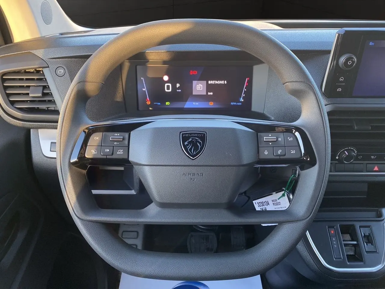 Vue rapprochée du volant noir du Peugeot Expert Cabine Approfondie 2025 avec tableau de bord numérique et écran tactile.