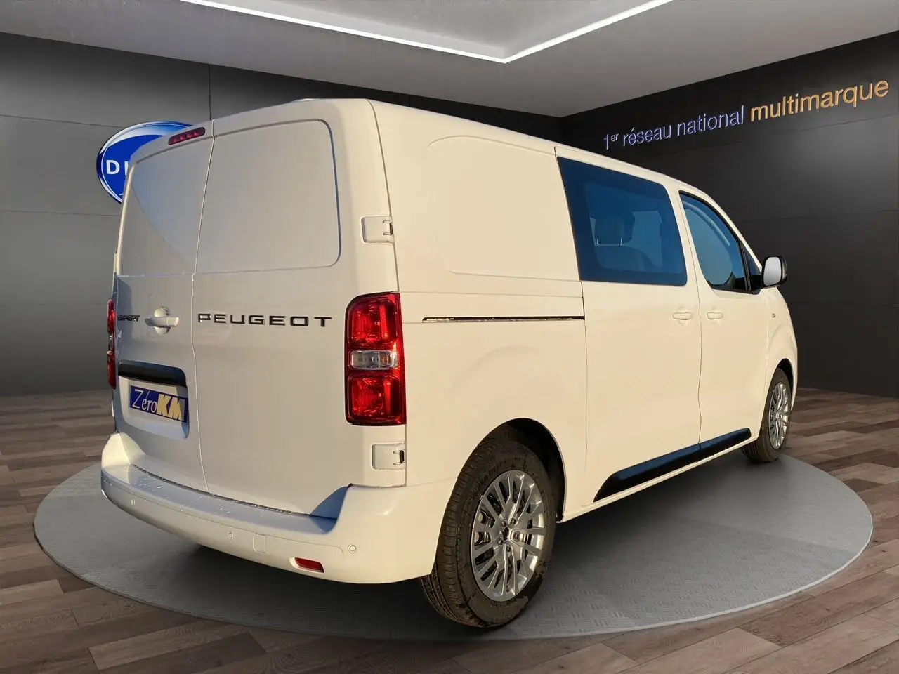 Vue 3/4 arrière droite du Peugeot Expert cabine approfondie blanc icy avec vitres teintées et jantes tôle noires 17 pouces.