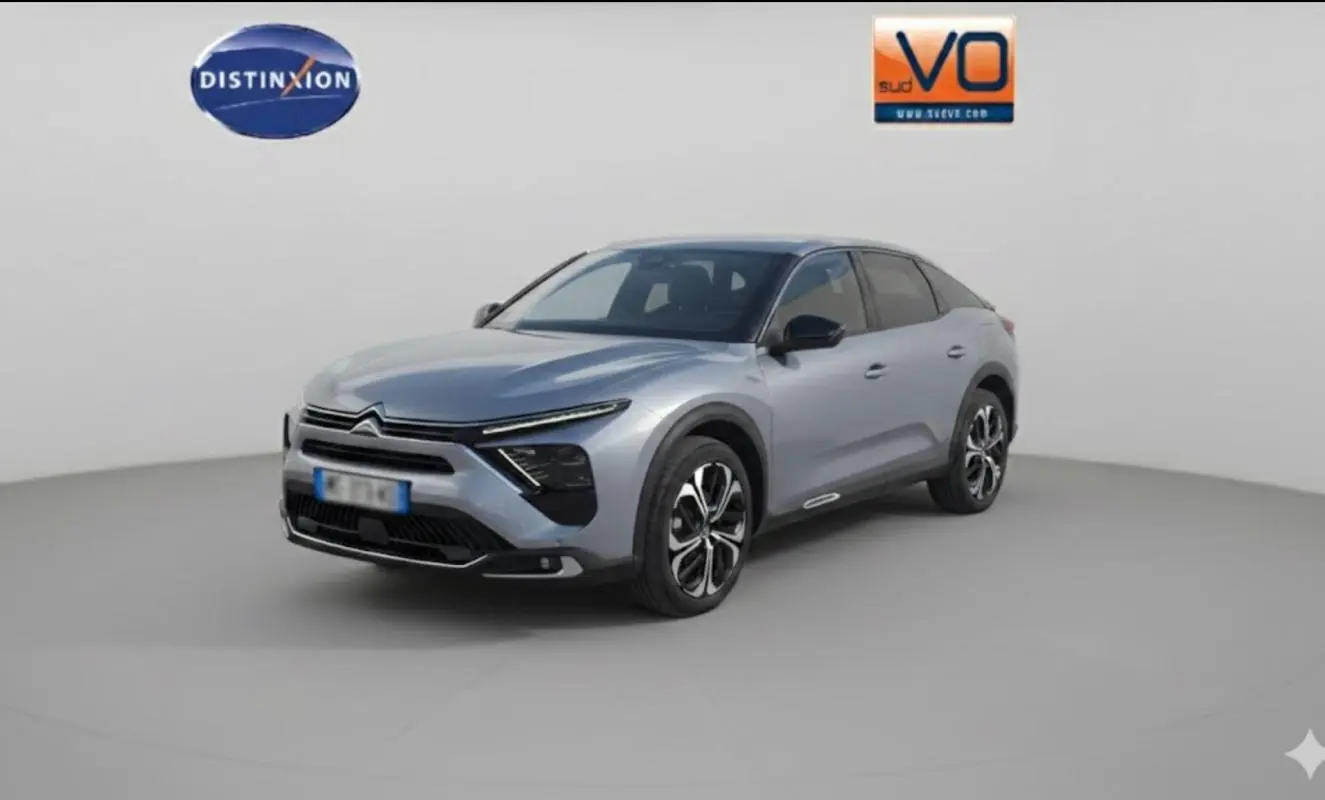 Vue 3/4 avant droit d'une Citroën C5 X gris foncé avec jantes alliage et toit noir dans un studio blanc.